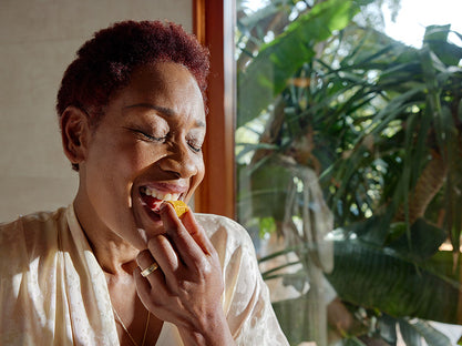 Woman enjoying her GEM Daily Essentials Citrus Ginger nutrient-dense multivitamin Bite.