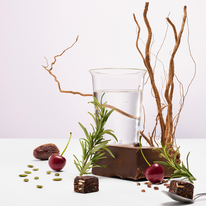 Chocolate dessert with cherries, rosemary, and dates on a white background